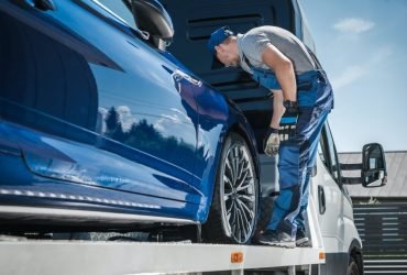 car-repossession-worker-securing-vehicle-on-his-towing-truck